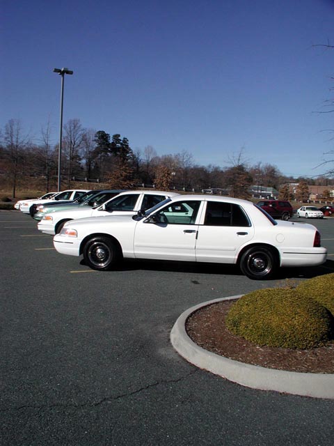 1998 Ford Crown Victoria - Side view of a white 1998 Ford Crown Victoria in a parking lot.