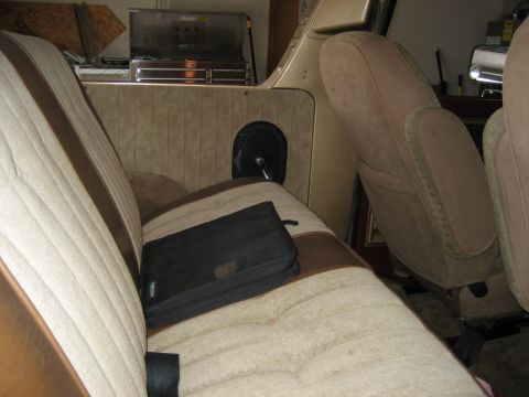 1979 Ford Bronco - The interior of the vehicle shows fabric seats and a storage compartment in the back.