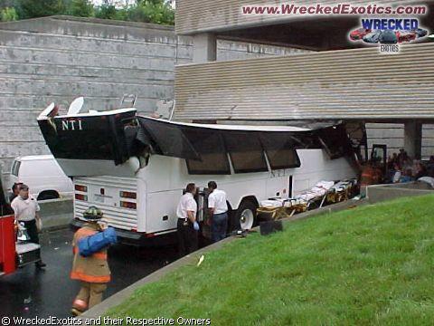 1996 Ford F-150 - A bus has crashed under an overpass, with emergency personnel and stretchers present. A van is also visible at the scene.