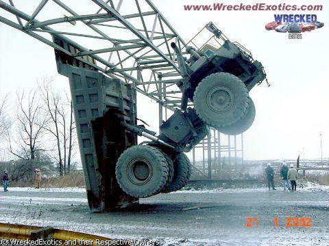 1996 Ford F-150 - A truck is precariously stuck in a large metal structure, with its large tires prominently displayed.