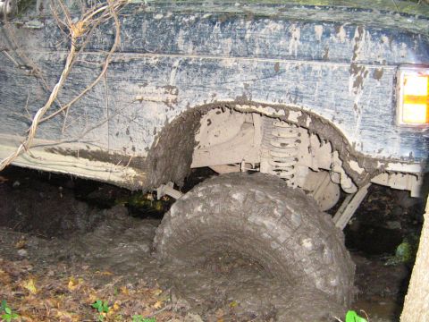 1990 Ford Bronco - This 1990 Ford Bronco is deeply stuck in thick mud, with the front wheel almost completely submerged.