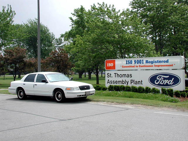 White Ford Crown Victoria sedan parked by St. Thomas Assembly Plant Ford sign