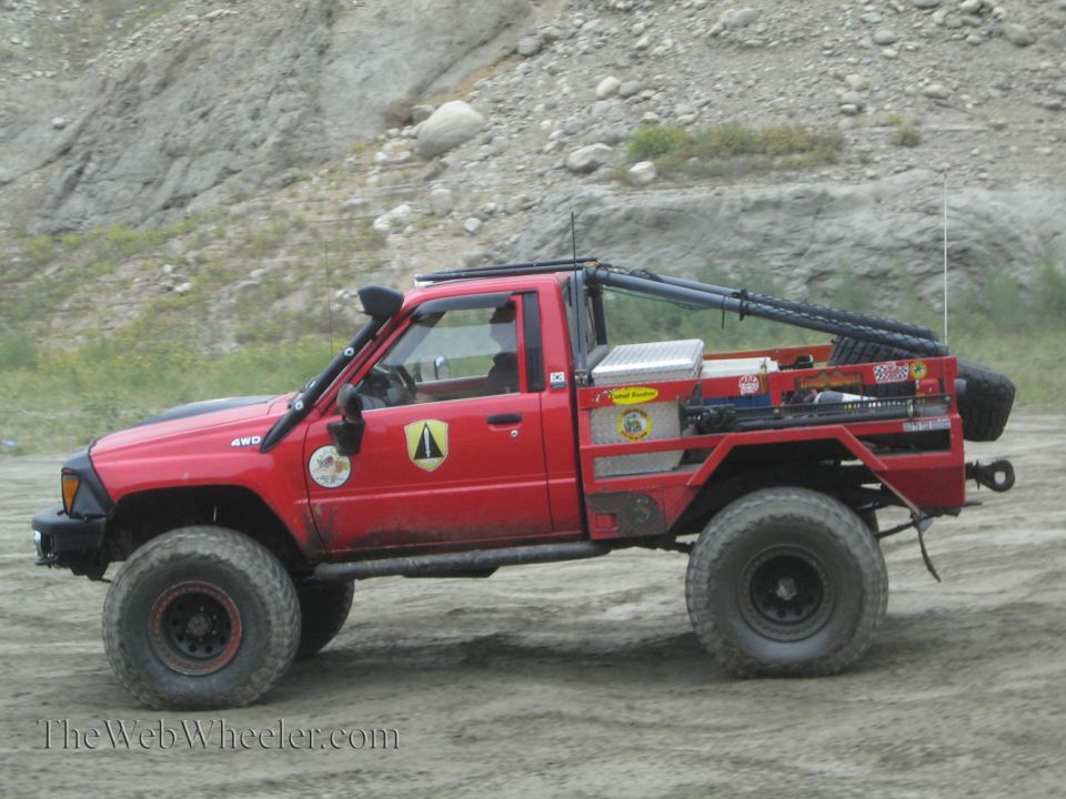 Red 1987 Toyota pickup truck with snorkel and flatbed