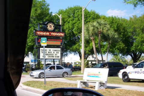 1979 Ford F-150 - A street scene shows a stadium sign, a silver sedan, a black minivan, and a police car.