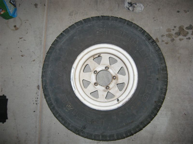 Spare tire with a white rim on a concrete floor