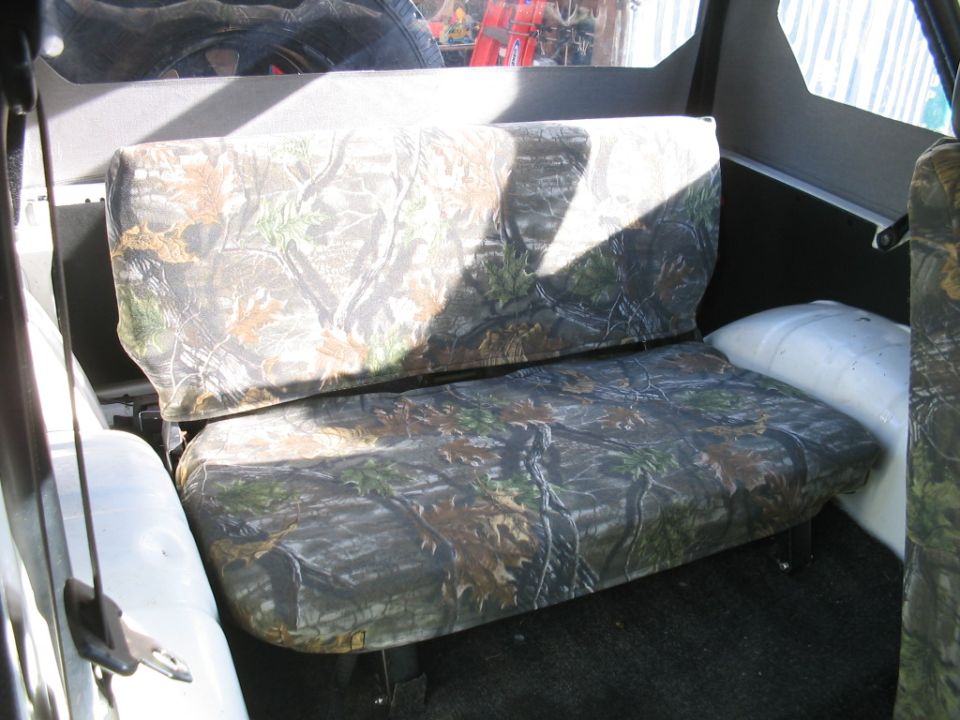 Camouflage-covered rear bench seat inside a vehicle