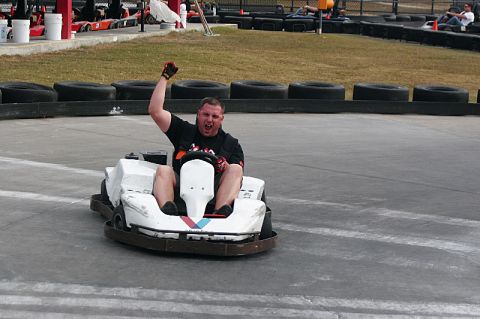 1994 Ford Probe - Go-kart racer celebrates on the track with other karts in the background.