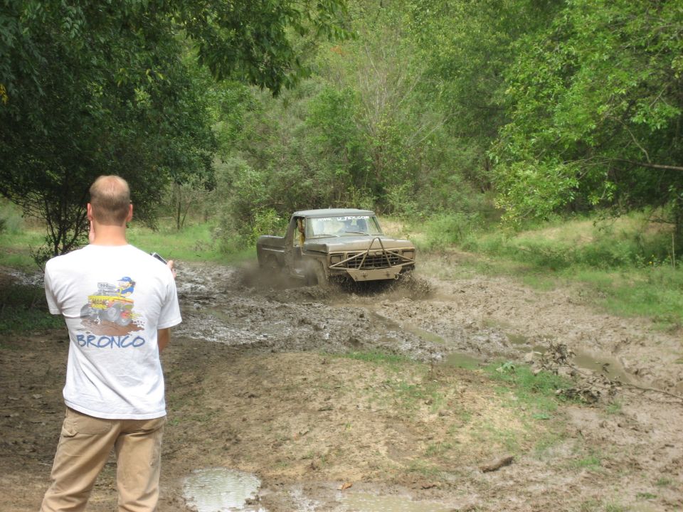 Ford F-Series truck with custom bumper driving through mud pit