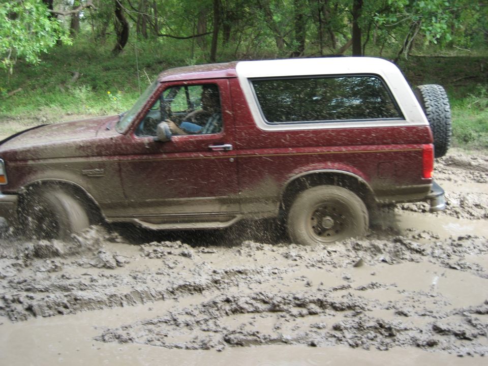 Red SUV stuck in mud, side view
