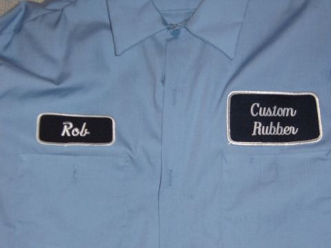 1993 Ford Bronco - A light blue work shirt displays embroidered patches on the chest, one with the name "Rob" and the other reading "Custom Rubber".