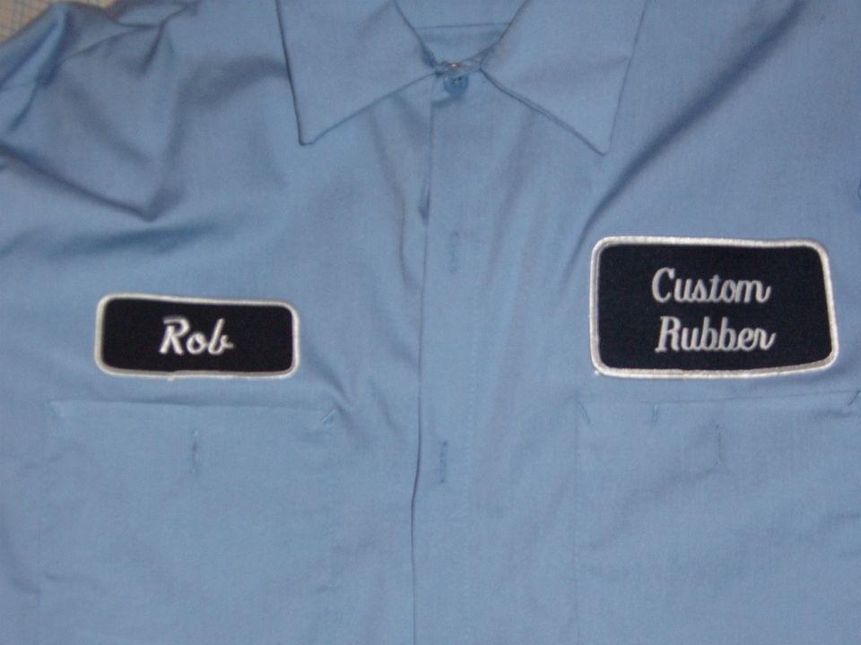 Blue work shirt with embroidered patches reading "Rob" and "Custom Rubber"