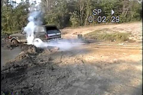 1989 Ford Bronco - This 1989 Ford Bronco appears to be stuck in a muddy area, with smoke billowing from its engine compartment.