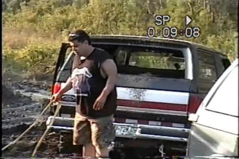 1989 Ford Bronco - A man attempts to free a 1989 Ford Bronco that is stuck in the mud.