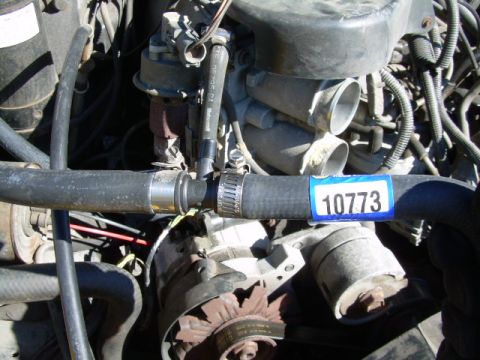 1988 Ford Bronco - Close-up of engine components, including a hose with a part number sticker.