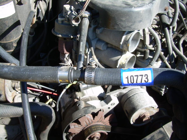 Engine bay detail showing a hose with a blue sticker labeled 10773
