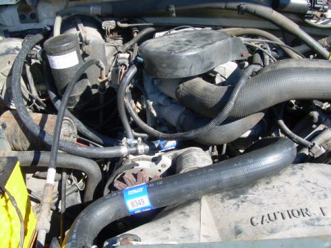 1988 Ford Bronco - Close-up view of an engine bay, focusing on hoses and engine components, with visible caution text.