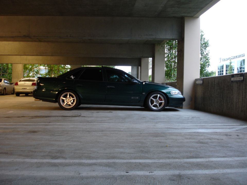 1993 Ford Taurus parked in a concrete garage, side view. Another car is visible in the background