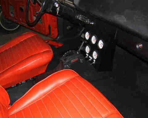 1967 Ford Ranchero - The interior of the vehicle features bright orange upholstered seats and a dashboard with multiple gauges.