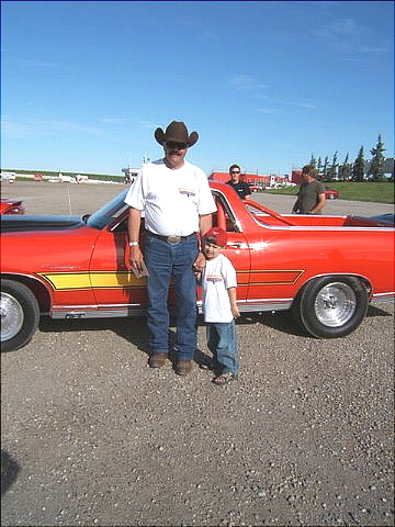 1967 Ford Ranchero - A man and a child pose next to a bright red 1971 Ford Ranchero with a distinctive yellow stripe.
