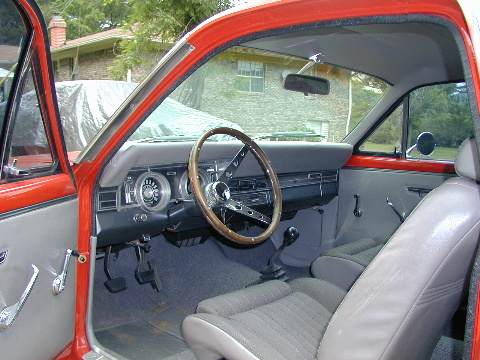 1967 Ford Ranchero - The interior of a 1967 Ford Ranchero shows a wood-rimmed steering wheel and grey upholstery.