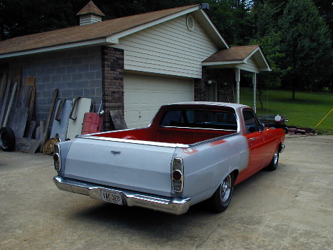 1967 Ford Ranchero - Rear view of a 1967 Ford Ranchero, showing a two-tone paint scheme with primer gray on the rear and red on the front.