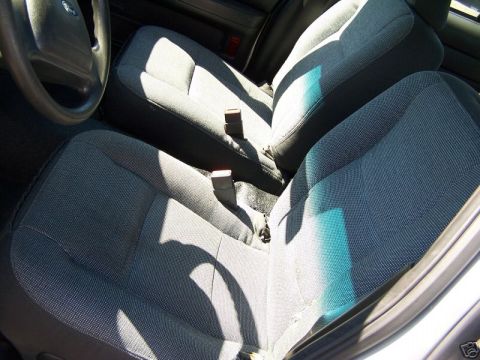 2003 Ford Crown Victoria - Front interior of a 2003 Ford Crown Victoria, cloth seats and a steering wheel.