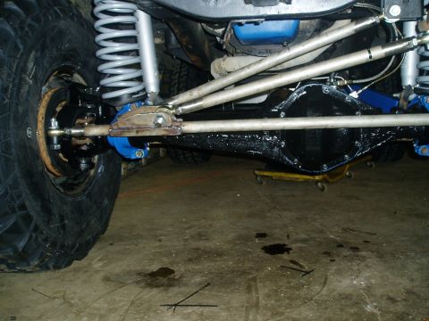 1969 Ford Bronco - The underside of a vehicle shows its suspension components and a differential, likely undergoing maintenance or modification.