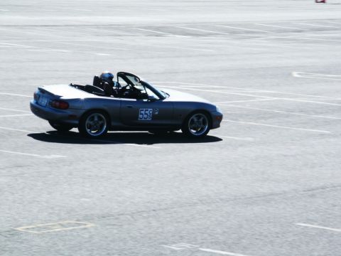 2001 Mercury Grand Marquis - A silver Mazda Miata convertible is seen on a paved track, displaying the number 55P on its door.