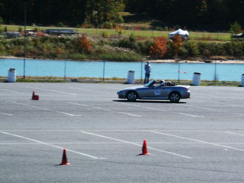 2001 Mercury Grand Marquis - A silver convertible sports car navigates a course marked by orange cones, with a person watching in the background.