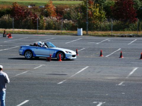 2001 Mercury Grand Marquis - A silver and blue convertible sports car navigates a course marked by orange cones on a paved lot.