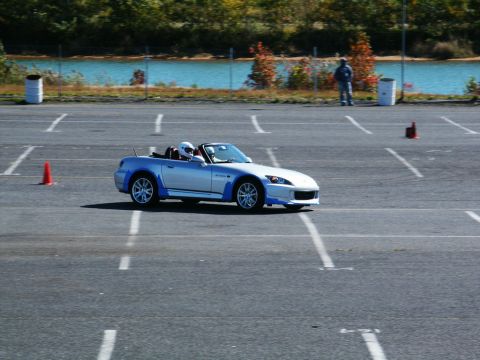 2001 Mercury Grand Marquis - A silver convertible sports car with blue accents navigates a course marked by cones on a sunny day.