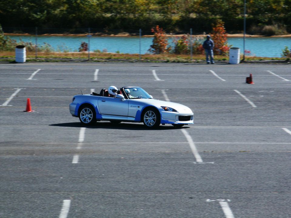 Silver convertible sports car with blue accents on a race track