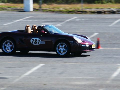 2001 Mercury Grand Marquis - Maroon Porsche Boxster with racing number 787 on the side is seen on a track.