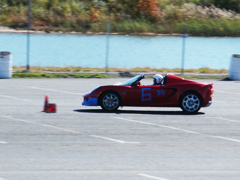Red convertible sports car with blue front bumper and number 6 SS on the side, driving on a track
