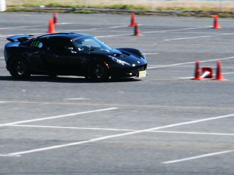 2001 Mercury Grand Marquis - A black sports car navigates a course marked by orange cones on a sunny day.