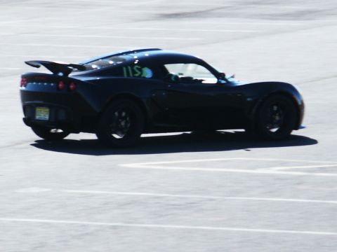 2001 Mercury Grand Marquis - A black sports car with racing numbers is parked on a paved lot.