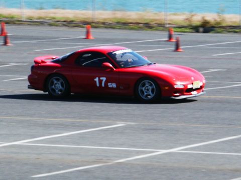 2001 Mercury Grand Marquis - A red Mazda RX-7 with racing numbers navigates a course marked by cones and painted lines.