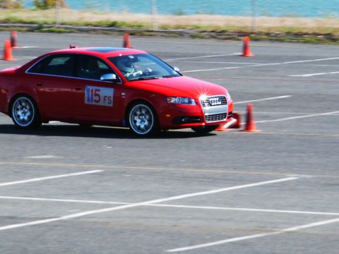 2001 Mercury Grand Marquis - A red sedan navigates a course marked by orange cones on a sunny day.