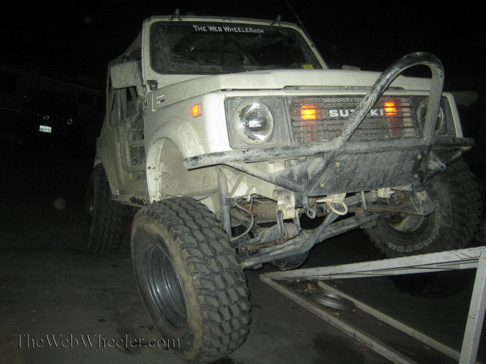 White 1987 Suzuki Samurai front view with custom bumper and off-road tires