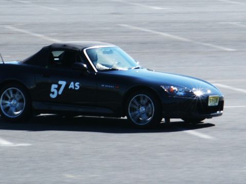 2001 Mercury Grand Marquis - A black convertible sports car with racing numbers is seen on a track.