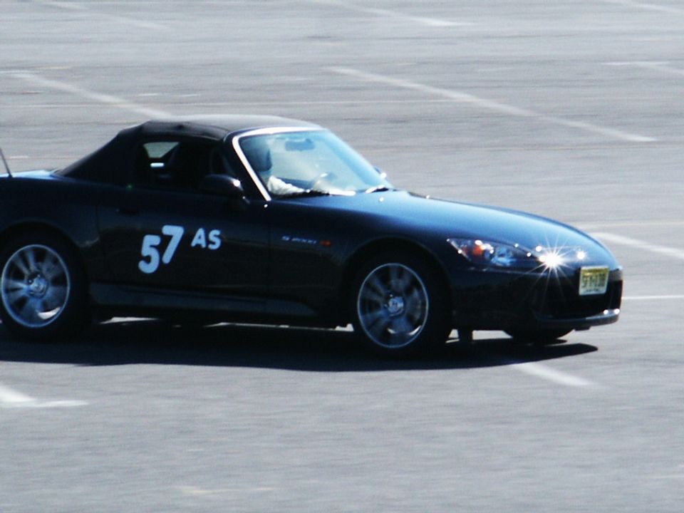 Black convertible sports car with white number 57 AS on the side, on a paved surface