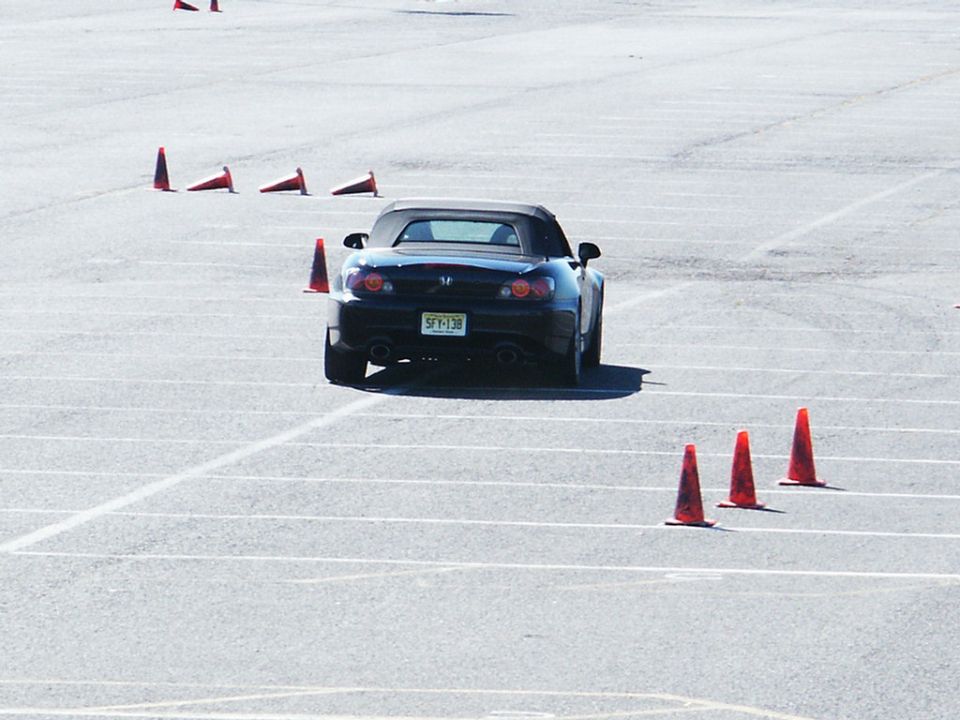 Black convertible sports car navigating a cone course