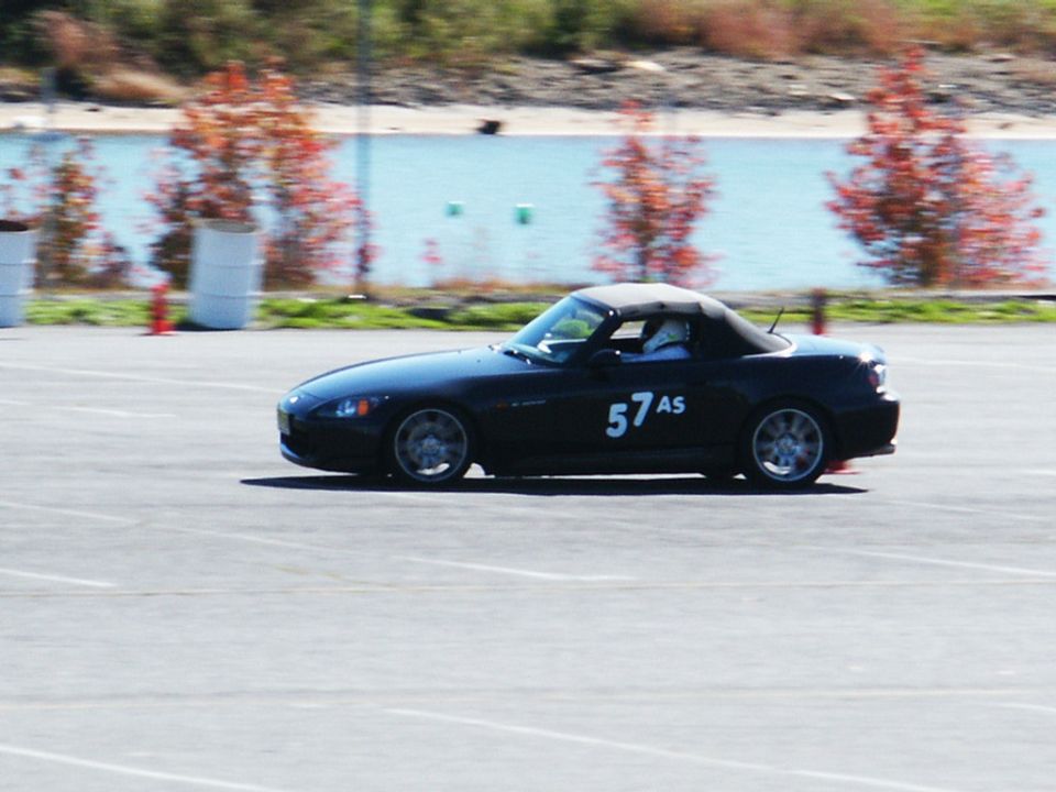 Black convertible sports car with number 57AS on the door, driving on a track