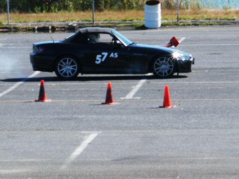2001 Mercury Grand Marquis - A black convertible sports car navigates a course marked by orange cones on a sunny day.
