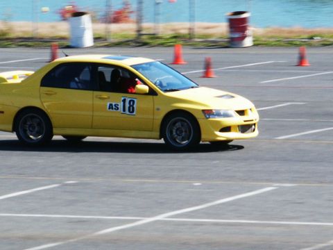 2001 Mercury Grand Marquis - A yellow sedan with racing number 18 navigates a course marked by cones.