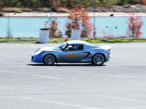 2001 Mercury Grand Marquis - A silver sports car with racing decals navigates a track on a sunny day.