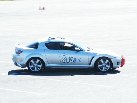 2001 Mercury Grand Marquis - A silver sports car with racing numbers navigates a track, indicated by orange cones.