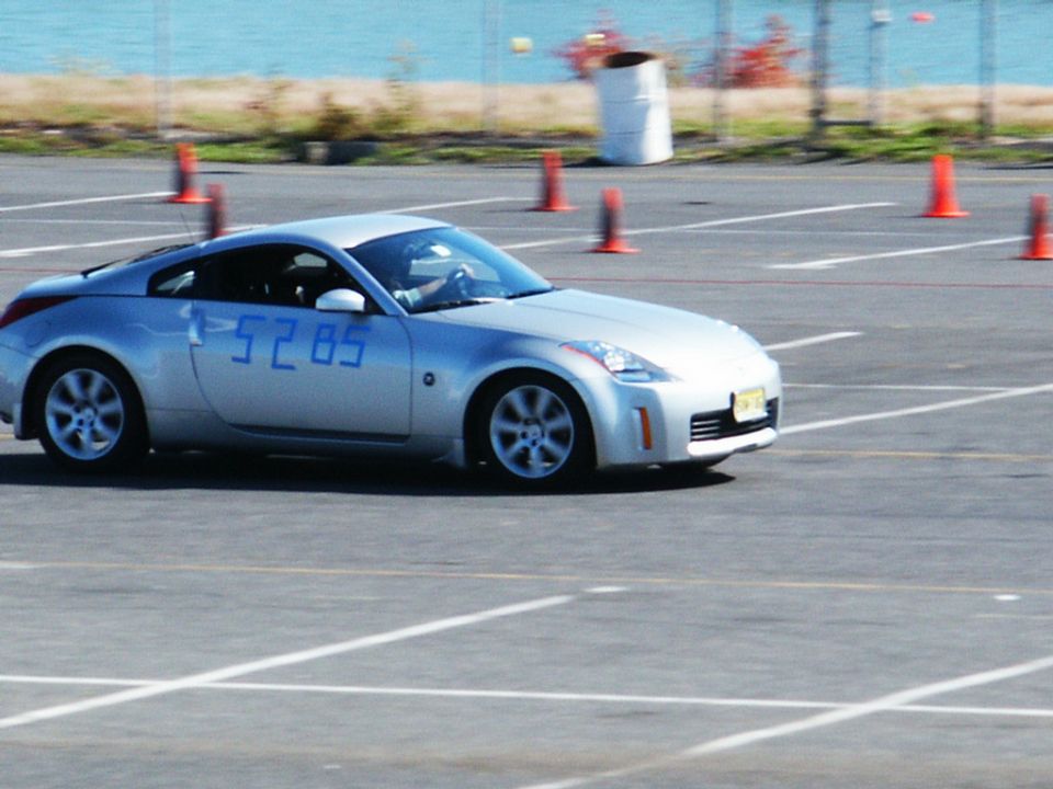 Silver coupe with blue numbers 1:52.85 on door, driving on track