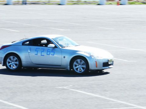 2001 Mercury Grand Marquis - Silver Nissan 350Z coupe with blue numbers 5285 on the driver's door is seen on a paved lot.