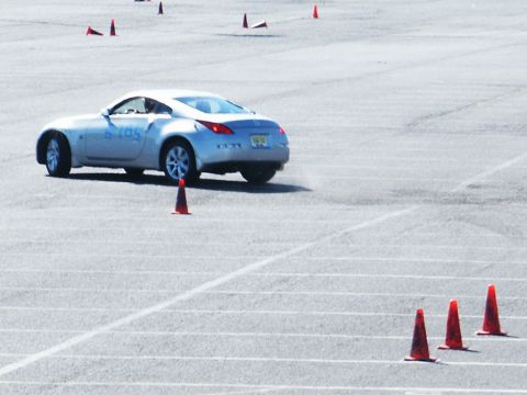 2001 Mercury Grand Marquis - A silver sports coupe navigates a course marked by traffic cones on a paved surface.